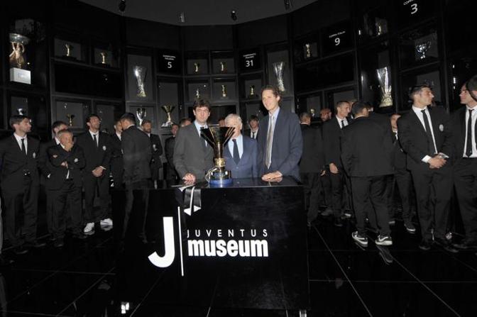 Dirigenti e giocatori della Juve tra i tanti trofei della storia bianconera. LaPresse